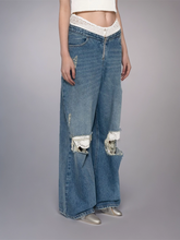 Jean à jambe large avec patchwork de dentelle et pompons en fourrure